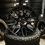 Black alloy wheel on a tire with stacked tires in the background