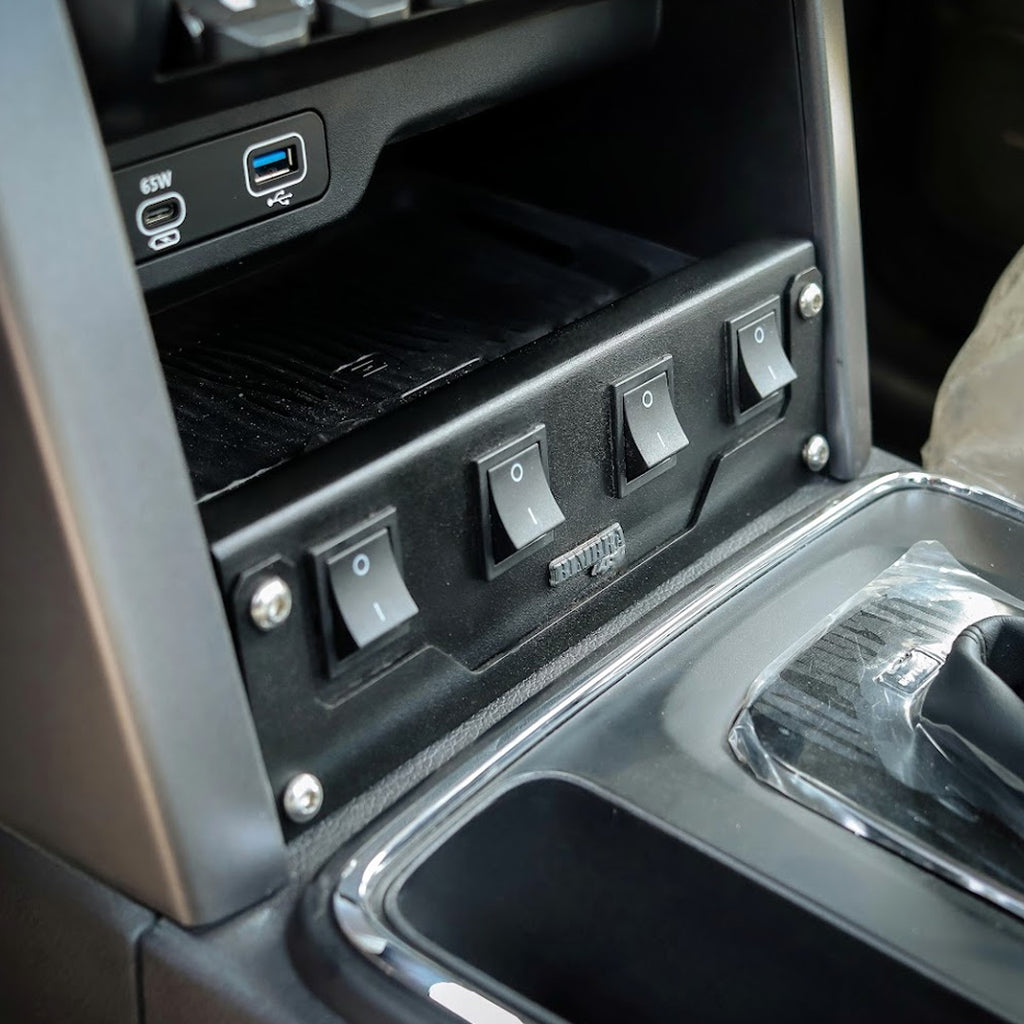 Close-up of a car's control panel with switches and USB ports.